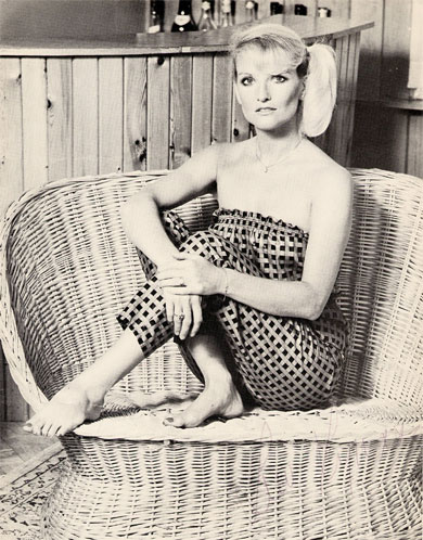 Lyn Paul sitting in a wicker chair.
